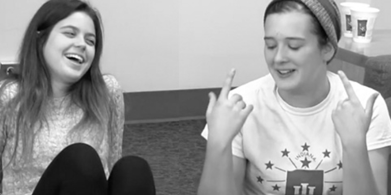 Two sitting on the floor, talking and laughing